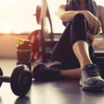 woman on floor exercising with dumbbell