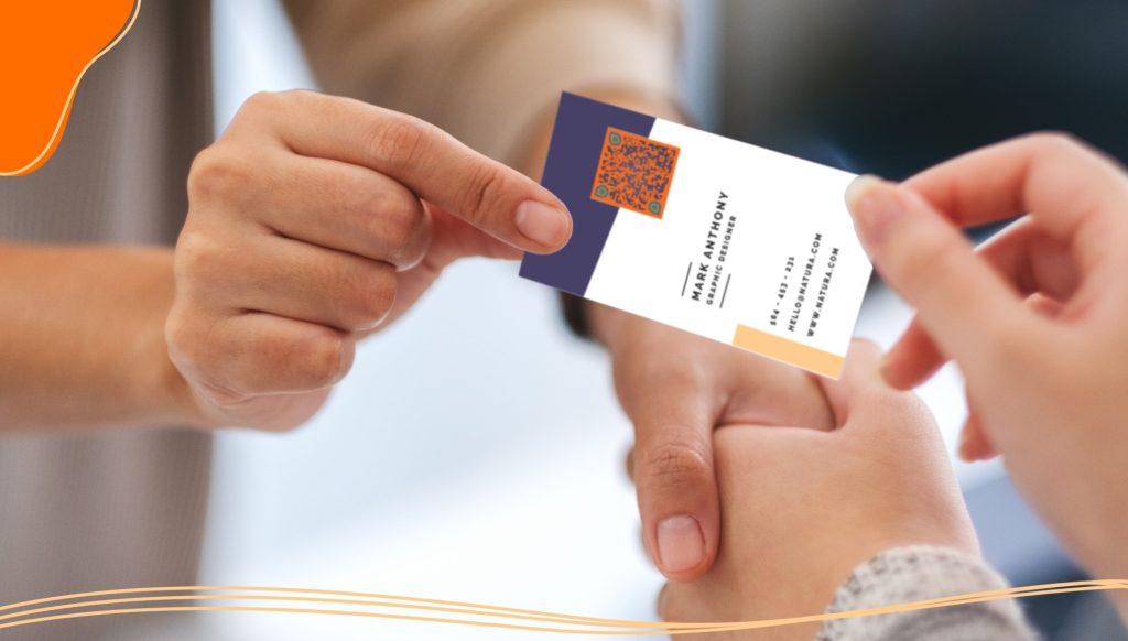 Two people shaking hands and exchanging a business card