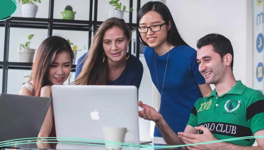 Business colleagues are smiling and working on a laptop.