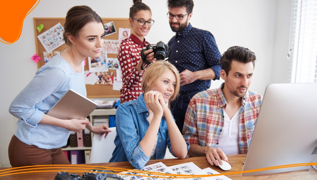 Group of co-workers looking at a computer