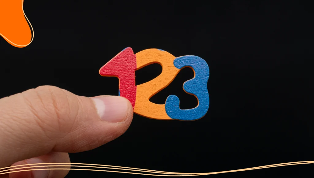 Fingers holding 123 colorful numbers.