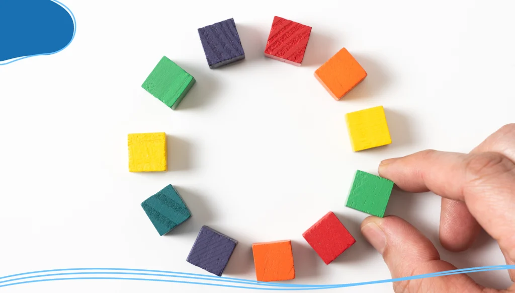 Person selecting from a circle of small colorful wooden squares