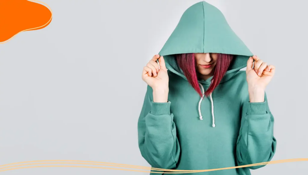 Woman covering her face with a branded hoodie