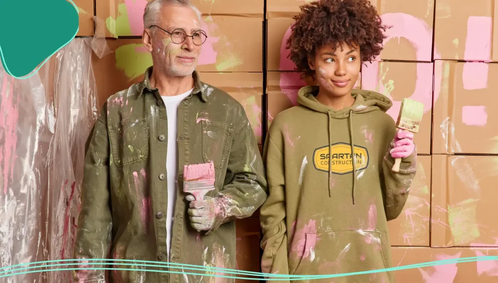 Man and woman standing side by side covered in pink paint