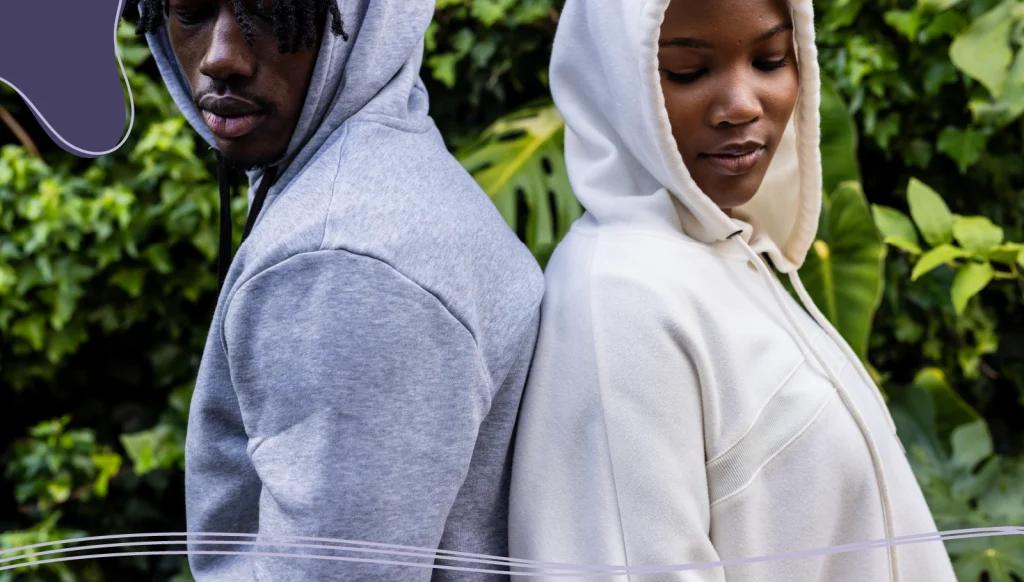 Two people standing back to back wearing promotional apparel made from organic cotton