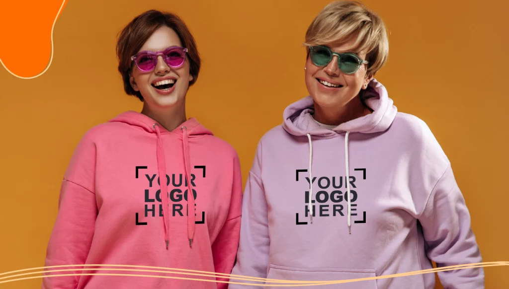 Two women standing next to each other wearing promotional apparel hoodies made of organic cotton