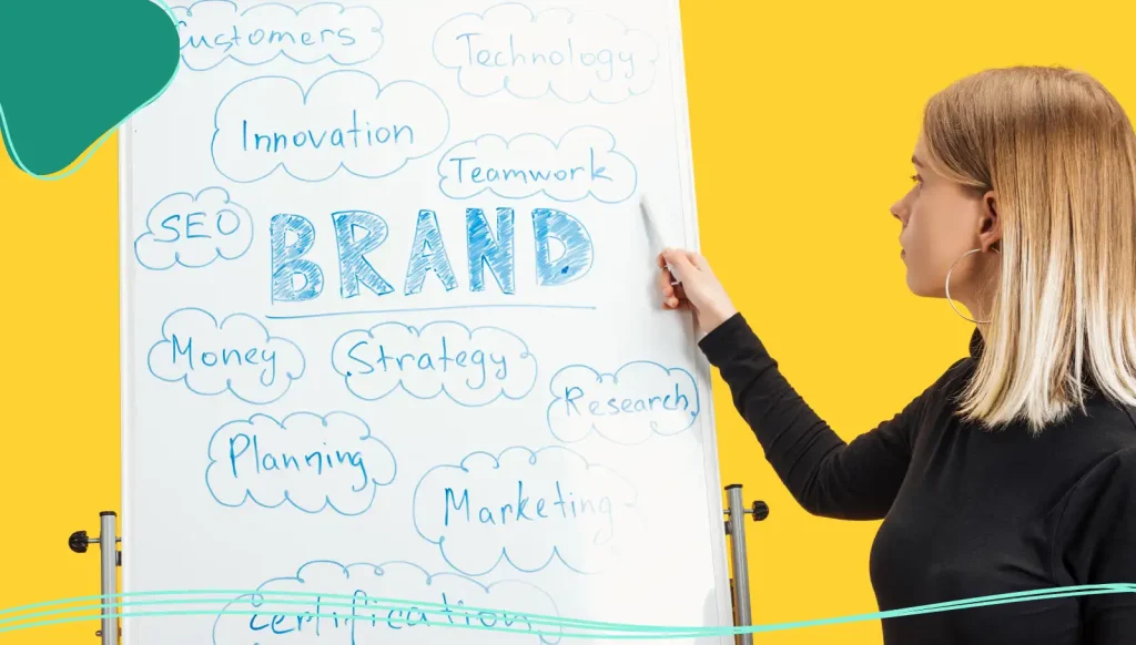 side view of businesswoman standing near white flipchart, pointing at words on flipchart.